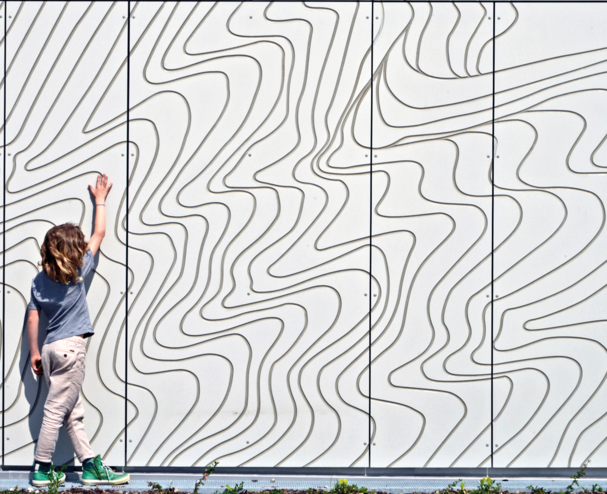 laps puudutab lasteaia freesitud fassaadi