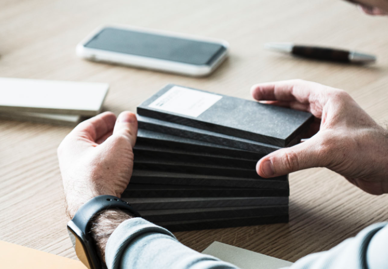 męskie dłonie dotykające próbek materiału EQUITONE