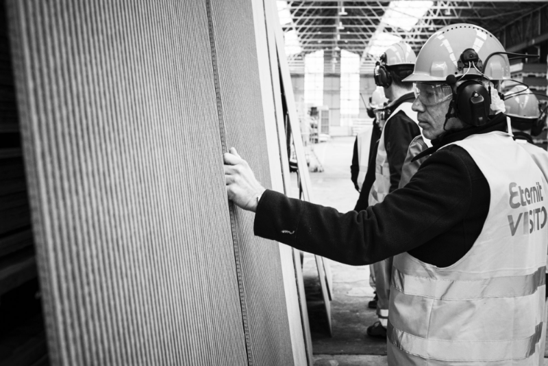 Mężczyzna w uniformie i kasku dotykający materiału EQUITONE linea