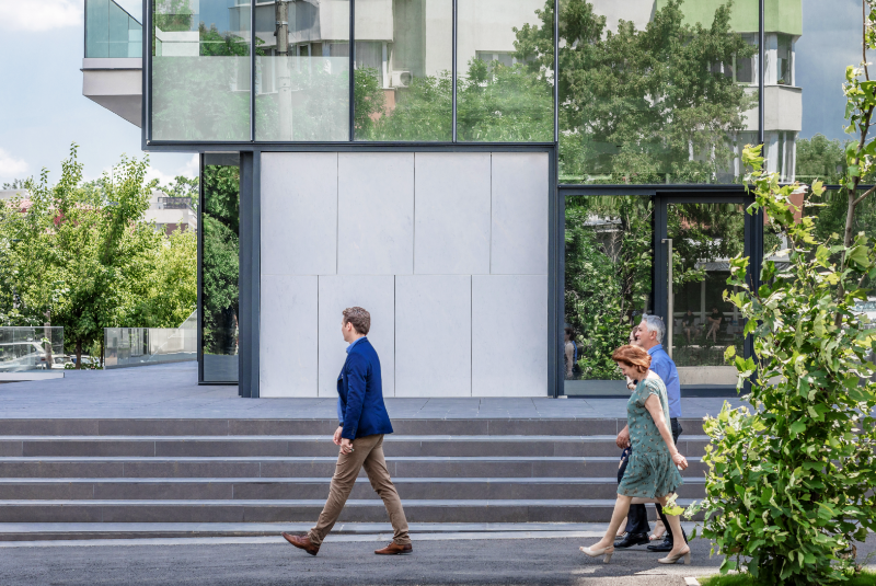 mees ja paar ventileeritava fassaadiga hoone ees