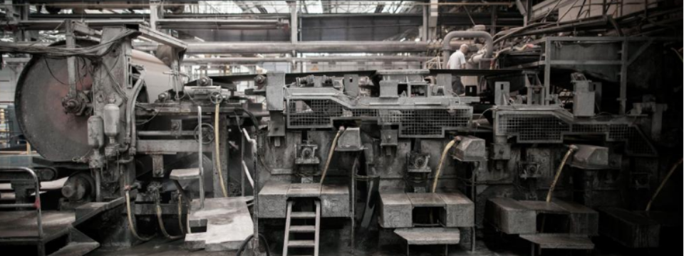 Industrielle Fertigungsanlage zur Herstellung von Faserzementtafeln – im Bild die klassische Hatschek-Maschine, Herzstück des Produktionsprozesses, bei dem Zellulose, Wasser, Zement und Fasern zu langlebigen Tafeln für hinterlüftete Fassaden verarbeitet werden.