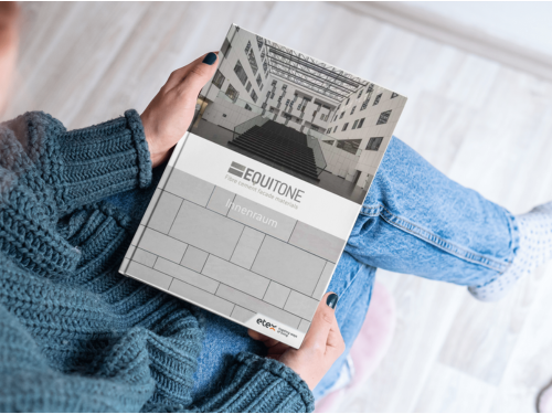 Innenansicht eines modernen Gebäudes mit vertikal gerillten Faserzementtafeln als Wandverkleidung – präzise Fugenausbildung, integrierte Elemente wie Uhr und Türöffnungen sowie eine harmonische Farbgestaltung unterstreichen den architektonischen Anspruch an Funktionalität und Design im Innenausbau.