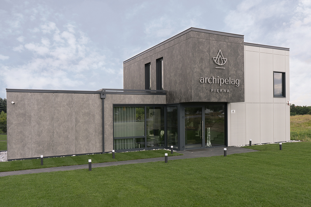 Modern commercial building facade featuring EQUITONE [inspira] fibre cement panels with a concrete-look matte finish in dual tones