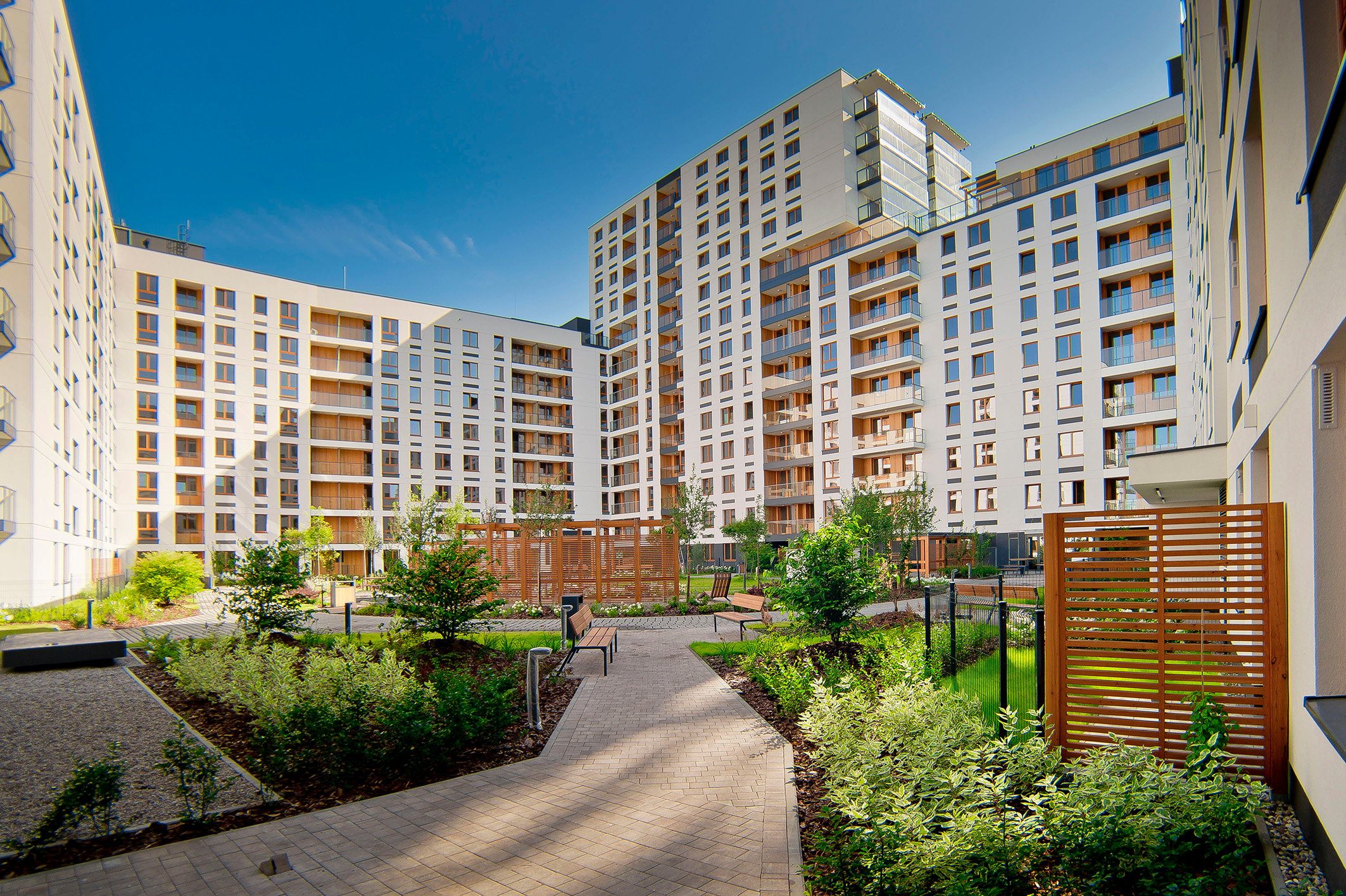 Large modern residential complex featuring EQUITONE fibre cement panels in a wood-inspired finish, highlighting innovative and sustainable architectural design.
